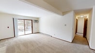 This 850 square foot apartment in Madison, Wisconsin offers a practical and cozy living space. The single-story layout comprises two bedrooms, one bathroom, a kitchen, and a living room. The primary bedroom measures 160 square feet, providing ample space for a comfortable retreat.

The living area features wall-to-wall carpeting and is anchored by a fireplace with a tiled surround, adding warmth and character to the space. Large windows, including sliding glass doors, allow natural light to flood the rooms and offer views of the surrounding area, including a snow-covered landscape visible in some images.

The galley-style kitchen is equipped with wooden cabinetry, granite countertops, and essential appliances including a refrigerator and stove. Tile flooring in the kitchen provides a durable and easy-to-clean surface.

The bathroom includes a combination tub and shower, a single vanity with a granite countertop, and matches the kitchen's tile flooring. Both bedrooms feature built-in closets for storage, and the apartment includes an additional closet space for extra storage needs.

Climate control is provided by baseboard heating and a window air conditioning unit, ensuring comfort throughout the seasons. The neutral color palette throughout the apartment offers a blank canvas for personalization.