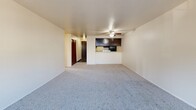 Located in the Meadowbrook neighborhood of Seattle, WA, this two-bedroom, one-bathroom unit offers a practical and well-organized single-floor layout. The open-plan living and dining area is carpeted and bathed in natural light from a large window, and features a ceiling fan overhead. A pass-through connects the living space to the galley-style kitchen, which is equipped with dark espresso cabinetry, light quartz-style countertops, wood-look vinyl flooring, and black appliances including a refrigerator, range, and dishwasher. A hallway leads from the entry to the private areas of the unit, including two carpeted bedrooms. The primary bedroom offers a generous footprint with a sliding glass door opening to a private balcony and views of surrounding greenery. The second bedroom features a large sliding-door closet, a baseboard heater, and a bright window with natural light. Throughout the unit, five closets provide exceptional storage. The full bathroom includes a wide vanity with dark cabinetry, a light countertop, a large mirror, and wood-look flooring. Baseboard heating is present throughout. The balcony offers an outdoor retreat with pleasant green views, completing this functional and comfortable Seattle residence.