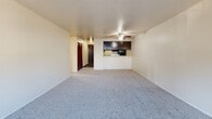 Located in the Meadowbrook neighborhood of Seattle, WA, this two-bedroom, one-bathroom unit offers a practical and well-organized single-floor layout. The open-plan living and dining area is carpeted and bathed in natural light from a large window, and features a ceiling fan overhead. A pass-through connects the living space to the galley-style kitchen, which is equipped with dark espresso cabinetry, light quartz-style countertops, wood-look vinyl flooring, and black appliances including a refrigerator, range, and dishwasher. A hallway leads from the entry to the private areas of the unit, including two carpeted bedrooms. The primary bedroom offers a generous footprint with a sliding glass door opening to a private balcony and views of surrounding greenery. The second bedroom features a large sliding-door closet, a baseboard heater, and a bright window with natural light. Throughout the unit, five closets provide exceptional storage. The full bathroom includes a wide vanity with dark cabinetry, a light countertop, a large mirror, and wood-look flooring. Baseboard heating is present throughout. The balcony offers an outdoor retreat with pleasant green views, completing this functional and comfortable Seattle residence.