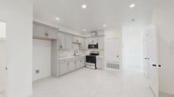 This thoughtfully designed two-bedroom, two-bathroom residence in Fontana, California offers a clean, modern aesthetic throughout its well-organized single-floor layout. Polished marble-look porcelain tile flows seamlessly across every room, creating a bright and cohesive feel enhanced by crisp white walls and recessed lighting.

The living area is an airy, light-filled space equipped with a ceiling fan and direct access to an outdoor patio via sliding glass doors, blending indoor and outdoor living effortlessly. The kitchen is a functional standout, featuring soft gray shaker-style cabinetry with matte black hardware, marble-look quartz countertops, a matching backsplash, and stainless gas range with overhead microwave.

Both bedrooms are generously proportioned, each outfitted with ceiling fans and ample closet space. The primary bedroom enjoys direct access to a private balcony with outdoor views, while the second bedroom benefits from its own closet and recessed lighting. Three closets in total provide abundant storage throughout.

The two bathrooms echo the home's refined palette, showcasing marble-look tile flooring, shaker-style vanities with quartz counters, matte black fixtures, and frameless sliding glass shower enclosures. A dedicated laundry area and connected hallway round out this well-planned residence, located in the Inland Empire community of Fontana, CA.