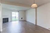 Located on Seawall Court in Virginia Beach, Virginia, this two-floor residence offers a functional and well-organized layout across both levels. The main floor centers around a spacious living area finished with warm wood-look flooring that extends throughout. A fireplace serves as a focal point in the living room, which also benefits from a sliding glass door that fills the space with natural light and provides outdoor access. A dedicated in-unit laundry closet with a full-size washer and dryer is conveniently integrated into the main living level. The kitchen is outfitted with white cabinetry, dark granite-style countertops, a coil-top electric range with overhead ventilation, and a hardwood-style floor that ties seamlessly into the main living area. The bathroom features a full soaking tub and shower combination with chrome fixtures set against clean, neutral walls and wood-look flooring. Upstairs, the bedrooms are carpeted for comfort and brightness, with large windows that allow generous natural light and views of the surrounding neighborhood. The staircase connecting both floors is visible in the architectural overview, reflecting a straightforward and practical two-story design. Overall, the residence presents a clean, neutral palette throughout, offering a versatile canvas well-suited to a variety of living arrangements.