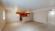 Located at 900 Valencia Dr SE in Albuquerque, New Mexico, this single-story, three-bedroom, two-bathroom home offers a functional and well-appointed layout. The combined kitchen and living area serves as the heart of the home, featuring light wood-look flooring, recessed lighting, and a ceiling fan. The kitchen is equipped with warm-toned wood cabinetry, a mosaic tile backsplash, granite-style countertops, and a peninsula that provides additional prep and dining space. The living area flows naturally from the kitchen, offering a bright, open feel with a window that lets in natural light. The bedrooms are carpeted in a neutral tan tone, providing warmth and comfort, and each includes sliding or hinged closet storage. The primary bedroom features two closets and a window overlooking the outdoors. The two bathrooms are finished with beige tile work accented by mosaic tile borders. One bathroom includes a tiled tub-shower combination with a window, while the other features a glass-enclosed walk-in shower with wood-look tile flooring. Neutral wall tones throughout the home create a cohesive, move-in ready atmosphere suited for comfortable everyday living.