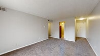 Located at 8006 Summerfield Cir in Louisville, Kentucky, this single-floor unit offers a straightforward, functional layout with a neutral color palette maintained throughout. The living area is generously proportioned, featuring plush wall-to-wall carpeting, a textured ceiling, and a sliding glass door fitted with vertical blinds that opens to a private outdoor patio, allowing natural light to filter into the space.

The kitchen stands out with updated finishes, including gray-toned cabinetry with brushed nickel hardware, granite-look countertops, a decorative mosaic tile backsplash, and black appliances including an electric range with overhead ventilation. Wood-look flooring in the kitchen provides a practical contrast to the carpeted areas elsewhere.

The bedrooms are carpeted and feature neutral walls, ceiling fans, and natural light from windows. Each bedroom includes a closet with louvered bifold doors and built-in shelving for organized storage.

The bathroom is clean and well-appointed, featuring a white vanity with under-sink cabinet storage, a wall-mounted mirror, tile-look flooring, and a frosted glass enclosure. The overall ambiance of the space is calm and move-in ready, with consistent neutral tones creating a cohesive feel from room to room.