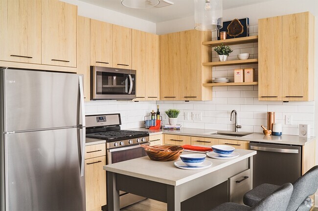 Stainless steel Whirlpool® appliances including gas range and hidden-control dishwashers - Vinings Lofts and Apartments