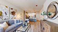 Located at 1721 Moon Lake Blvd in Hoffman Estates, Illinois, this single-floor, 3-bedroom, 2-bathroom residence offers a thoughtfully designed open-concept layout that maximizes its well-utilized footprint. The living area flows seamlessly into the kitchen, creating a connected and functional common space. Light-toned wood-style flooring runs throughout the main areas, complementing the neutral warm-gray wall palette and contributing to a bright, cohesive aesthetic.

The kitchen is a standout feature, showcasing two-tone cabinetry with white upper cabinets and gray lower cabinets, white quartz countertops, a tile backsplash, and stainless steel appliances. A peninsula with bar seating serves as a natural dividing element between the kitchen and living space.

The living room benefits from large windows that introduce natural light and outdoor views, while providing ample room for comfortable seating arrangements. The primary bedroom is a generously proportioned retreat with plush carpeting, a large window with outdoor views, and a serene, neutral finish.

The two bathrooms are finished consistently with gray cabinetry and wood-style flooring. One features a glass-enclosed walk-in shower, while the other includes a full tub-shower combination, both maintaining a clean, contemporary character throughout.