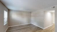 This two-story, three-bedroom, two-bathroom townhome at 7004 Tama Rd in Columbia, SC is thoughtfully laid out across two evenly divided floors. The main level features a living room and a well-appointed kitchen equipped with white cabinetry, granite countertops, a subway tile backsplash, black appliances including an electric range and refrigerator, and a stainless steel sink — all accented by light wood-look luxury vinyl plank flooring. A hallway and one bathroom with a vanity and mirror complete the lower level. Upstairs, three bedrooms offer comfortable accommodations, including a spacious primary bedroom. The bedrooms feature a mix of soft carpet and LVP flooring, ceiling fans, and windows with blinds that invite natural light and outdoor views of surrounding greenery. Neutral gray walls and white trim carry throughout, creating a clean, cohesive aesthetic. Textured ceilings are consistent across all rooms. The secondary bedrooms each include closet space, and a second full bathroom serves the upper floor. The overall ambiance is bright, functional, and move-in ready, with modern updates that provide a fresh, contemporary feel well-suited for comfortable everyday living in Columbia, SC.