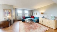 Located at 401 Cumberland Ave in the heart of Portland, Maine, this two-bedroom, one-bathroom residence offers a well-designed single-floor layout with a comfortable and functional flow throughout. Warm hardwood flooring runs continuously through the main living areas, complementing the neutral wall tones that lend the space a bright, cohesive feel.

The combined kitchen and living room area forms the social hub of the home. The kitchen is outfitted with white cabinetry, stainless steel appliances including a range, microwave, dishwasher, and refrigerator, and ample counter space. The living room features large windows that invite natural light and offer views of the Portland cityscape, creating an airy atmosphere.

The generously sized primary bedroom is bathed in natural light from multiple windows fitted with woven roman shades, and includes closet storage. The second bedroom offers flexibility as a guest room or home office. The full bathroom includes hardwood flooring, a shower-tub combination, and a white vanity. A dedicated in-unit laundry room provides added convenience with a front-loading washer and dryer alongside shelving for storage. A connecting hallway ties the rooms together efficiently, completing this well-appointed Portland residence.