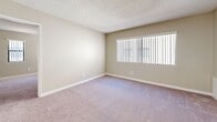 Located at 101 Bridewell St in the Highland Park neighborhood of Los Angeles, CA, this 2-bedroom, 2-bathroom unit offers a well-designed single-level floor plan with a cohesive, neutral aesthetic throughout. The open-concept living and dining areas flow seamlessly from the kitchen, which is outfitted with crisp white shaker cabinets, speckled quartz countertops, a stainless steel refrigerator, gas range, and over-the-range microwave. Light wood-style flooring anchors the kitchen and main living spaces, while plush carpeting carries through the bedrooms and living room, adding warmth underfoot. The spacious primary bedroom features mirrored sliding closet doors that enhance the sense of space, and direct access to one of the two full bathrooms. Both bathrooms are finished with white cabinetry, quartz-topped vanities, wood-style flooring, and full tub-shower combinations with white tile surrounds. The second bedroom benefits from multiple windows fitted with vertical blinds, filling the room with natural light. Three dedicated closets provide generous storage throughout. Textured ceilings and warm beige walls create a clean, move-in-ready environment suited for comfortable everyday living.