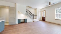 Located at 3810 Cascade Sky Dr in Arlington, TX, this two-story home offers 3 bedrooms and 4 bathrooms across a well-designed layout. The main floor serves as the social hub, featuring an open-concept kitchen and living room anchored by light hardwood-style flooring. The kitchen is a standout, boasting soft gray cabinetry, a striking teal center island with white quartz countertops, stainless steel appliances, and stylish pendant lighting. The adjacent living room is bright and airy, with multiple windows dressed in blinds, a ceiling fan, and views of the surrounding greenery. A cleverly integrated built-in desk beneath the staircase maximizes functionality, while the staircase itself features elegant dark wood railings. A half bath with marble-style tile flooring is also conveniently located on the main level. Upstairs, the three bedrooms are carpeted and well-proportioned, each served by their own bathroom access. The generously sized primary bedroom includes a walk-in closet with dual hanging rails and built-in shelving. The bathrooms feature marble-look tile surrounds, teal vanities with white countertops, and modern fixtures. The upper floor offers more living space, making it ideal for family or guests.