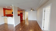 Located at 2858 W Ball Rd in Anaheim, California, this single-floor unit offers a well-organized layout with a cohesive design throughout. Rich hardwood-style flooring runs through the main living areas, complemented by crown molding and a textured ceiling that adds depth and character to the space.

The open living area is spacious and inviting, featuring a ceiling fan with a brushed nickel finish and clean white walls that allow for versatile décor options. A front entry door with transom windows brings in natural light, creating a bright and welcoming atmosphere from the moment you step inside.

The kitchen is a standout feature, showcasing bold terracotta-red accent walls that contrast sharply with light maple cabinetry and dark granite countertops. Black appliances, including a range and over-the-range microwave, are integrated seamlessly into the design. Recessed lighting overhead and a raised breakfast bar that opens to the living area make this kitchen both functional and visually striking.

The bedroom is comfortably sized with soft carpeting underfoot, a ceiling fan with light fixture, and mirrored sliding closet doors that enhance the sense of space. The bathroom is clean and functional, featuring a tub/shower combination with a sliding glass enclosure, wood-toned vanity, and hardwood-style flooring for a cohesive finish.