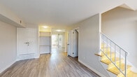Located at 3314 Wickslow Rd in Wilmington, NC, this two-story home offers a clean, modern aesthetic complemented by consistent light-toned, hardwood-style flooring that flows seamlessly throughout both levels. The main floor presents an open, airy layout with a welcoming living area featuring built-in shelving, a staircase with wood-accented railings, and sliding glass doors that invite natural light and provide access to the outdoors. The updated kitchen is well-appointed with crisp white shaker cabinetry, granite countertops, a classic subway tile backsplash, and stainless steel appliances including a refrigerator and dishwasher. A convenient half bathroom on the main level features a pedestal sink and neutral finishes. A dedicated laundry area with a stacked washer and dryer adds practical functionality. Upstairs, the bedrooms are bright and generously proportioned, each benefiting from natural light through windows dressed with blinds. The upper-level full bathroom is thoughtfully finished with a white vanity, granite countertop, framed mirror, and a tiled shower/tub combination. A bright hallway connects the upper rooms, enhanced by a window that draws in abundant natural light. The home's neutral palette and updated finishes create a cohesive, move-in-ready atmosphere throughout.