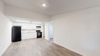 Located in Hialeah, FL, this 2-bedroom, 1-bathroom single-floor unit offers a practical and well-designed layout that makes efficient use of its space. Wood-look plank flooring runs throughout the unit, providing a cohesive and warm aesthetic across all rooms.

The open living and kitchen area forms the heart of the unit. The kitchen features crisp white shaker cabinets, a marble-look countertop, a stainless steel sink, and a black electric range with an overhead vent hood — all well-lit by overhead fluorescent lighting. A hallway leads from the kitchen to a utility area housing the water heater, keeping functional elements neatly tucked away.

Both bedrooms are bright and clean, with white walls, wood-look flooring, and windows that allow natural light to filter in. The primary bedroom offers a comfortable footprint and includes views of the surrounding greenery. Each room provides a neutral canvas well-suited for a variety of furnishing arrangements.

The full bathroom is finished with large-format gray tile surrounding the tub and shower, paired with a white vanity and wood-look tile flooring, giving it a clean and contemporary feel.

Overall, this unit presents a well-maintained, functional living space with consistent finishes, ample natural light, and a straightforward layout ideal for everyday living.