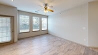 Located at 2301 Presidio Vista Dr in Fort Worth, TX, this single-story 2-bedroom, 2-bathroom home offers a thoughtfully designed open-concept layout. The combined living, dining, and kitchen area serves as the heart of the home, finished with light wood-style flooring throughout and ceiling fans to promote airflow. The kitchen is a standout feature, showcasing rich dark wood cabinetry, a subway tile backsplash, black appliances including a range and refrigerator, a stainless steel microwave, and track lighting overhead. A large center island with a quartz countertop and double stainless steel sink provides generous prep space and doubles as a casual dining area. The dining and living spaces benefit from natural light streaming through multiple windows, with a glass door leading directly to the private patio. Both bedrooms are well-proportioned, with the primary bedroom offering notable square footage, dual windows for natural light, a ceiling fan, and access to multiple closets. The bathrooms feature quartz countertops, dark wood vanities, and wood-style tile flooring, with one bath including a soaking tub and tiled surround. A dedicated laundry room houses a full-size washer and dryer alongside built-in shelving for added storage.