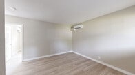 Located at 4706 Yellowstone Blvd in Houston, TX, this one-bedroom, one-bathroom unit offers a thoughtfully arranged single-floor layout. Light wood-style flooring runs throughout, complementing a neutral warm-gray color palette that lends a clean, cohesive feel to every room.

The living room is an open, well-lit space with smooth white ceilings and generous wall space, flowing naturally toward the rest of the unit. A ductless mini-split air conditioning unit provides efficient climate control. The kitchen is a functional galley-style space featuring white shaker cabinets with matte black hardware, gray countertops, a stainless steel refrigerator, an electric range, and a single-basin sink beneath a window that brings in natural light.

The bedroom is a comfortable, well-proportioned room equipped with its own wall-mounted mini-split unit for personalized climate control. A sliding double-door closet offers dedicated storage, and a horizontal window frames views of surrounding greenery. Direct access leads to the bathroom, which includes a soaking tub and shower combination with white tile surround, a vanity with cabinet storage, and a window providing natural ventilation. Clean white trim and consistent flooring tie all spaces together for a polished, move-in ready presentation.