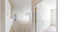 Located at 9210 N Coursier Ln in Spokane, WA, this single-floor, 2-bedroom, 1-bathroom home offers a clean and functional layout designed for comfortable everyday living. The open living area is bright and inviting, featuring soft carpeting, a ceiling fan, vaulted ceilings, and large windows that allow natural light to fill the space. A sliding glass door provides access to the outdoors, further enhancing the airy feel of the room. The kitchen is well-appointed with warm oak cabinetry, a tile backsplash, ample counter space, a peninsula island, and white appliances including a range and refrigerator. Tile flooring and tall ceilings give the kitchen a practical yet open character. The primary bedroom is generously sized, with carpeted floors and six-panel doors that carry a consistent design throughout the home. A dedicated walk-in closet with wire shelving provides excellent storage. The full bathroom features a clean tub-shower combo with chrome fixtures. A conveniently located in-unit laundry room houses a full-size washer and dryer beneath a bright window. Throughout the home, a neutral color palette and consistent finishes create a cohesive, move-in-ready environment.