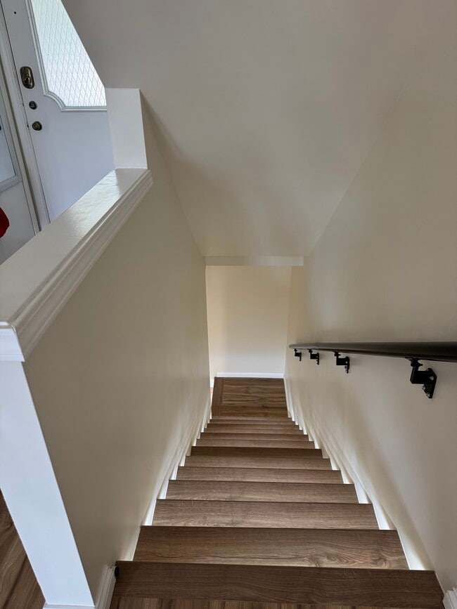 Modern wood staircase with motion-sensor LED lighting—sleek, safe, and energy-efficient design. - 328 N Allen St