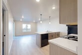 Located at 3201 N. Martindale Rd in Sioux Falls, SD, this thoughtfully designed 2-bedroom, 2-bathroom unit offers a clean, modern aesthetic across a single floor. The open-concept kitchen and living area serves as the heart of the home, featuring light wood-look flooring, recessed lighting, and stylish pendant lights over a peninsula island with a built-in sink and ample counter space. Taupe cabinetry, light quartz-style countertops, and black appliances — including a refrigerator, range, microwave, and dishwasher — complete the well-equipped kitchen. The adjoining living area is bright and open, with a window that brings in natural light. Both bedrooms are carpeted and include ceiling fans and windows for ventilation and natural light. The primary bedroom offers a comfortable, private retreat with direct access to its own bathroom. The bathrooms are finished with tile flooring, vanities with white countertops, and taupe cabinetry with dark hardware. A dedicated laundry space houses a stacked Whirlpool washer and dryer, adding everyday convenience. The unit also includes a hallway, closet, and a cohesive neutral color palette throughout, creating a clean and contemporary living environment.