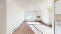 Located at 3335 Austin Bluffs Pkwy in Colorado Springs, CO, this single-floor, 3-bedroom, 1-bathroom unit offers a practical and functional layout. The living room is bright and welcoming, featuring large windows that flood the space with natural light, neutral carpet flooring, baseboard heating, and a textured ceiling. A wall-unit air conditioner provides additional climate control comfort.

The galley-style kitchen is efficiently designed with white cabinetry, granite-style countertops, a double-basin sink, and white appliances including a range and refrigerator. Light wood-style flooring ties the kitchen together cleanly.

The three bedrooms are carpeted and finished with crisp white walls and textured ceilings. Each room benefits from natural light through windows fitted with vertical blinds or curtains, and baseboard heaters ensure warmth throughout. The primary bedroom includes a vanity area with a sink and mirror, along with a closet for dedicated storage. Two additional closets serve the unit's overall storage needs.

The bathroom features a full tub-shower combination with a curved curtain rod and light wood-style flooring. A connecting hallway ties the rooms together in a straightforward, easy-to-navigate floor plan. Overall, this unit presents a clean, neutral palette well-suited for comfortable everyday living.