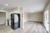 Located at 3030 Elmside Dr in Houston, TX, this single-floor 2-bedroom, 2-bathroom residence offers a clean, modern aesthetic throughout. Light wood-style laminate flooring runs continuously across the living areas and bedrooms, complemented by neutral warm-gray walls and textured ceilings that create a cohesive, welcoming atmosphere.

The kitchen is well-appointed with white shaker-style cabinetry, granite-look countertops, a subway tile backsplash, and black appliances including a refrigerator, range, and dishwasher. It flows naturally into the adjacent dining and living areas, making the layout practical for everyday living and entertaining.

The living room is open and bright, with ample space and clean sightlines. Both bedrooms feature ceiling fans with light fixtures, built-in closets, and windows that bring in natural light. The primary bedroom includes a spacious closet and comfortable square footage.

The two bathrooms are finished with subway tile surrounds — one featuring a tub/shower combo with a curved curtain rod and granite-top vanity, and the other offering a standalone walk-in shower with chrome fixtures. A dedicated utility room and four closets throughout provide generous storage. The layout is efficient and well-organized, connected by a central hallway.