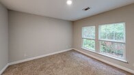 Located at 2109 Oglethorpe Circle in Pooler, Georgia, this single-story, 2-bedroom, 2-bathroom home offers a practical and comfortable layout. The entrance opens to a tile-floored common area that flows through the main living spaces. The kitchen is equipped with rich wood cabinetry, light countertops, and white appliances including an electric range, dishwasher, and refrigerator, complemented by a window that brings in natural light. Both bedrooms feature warm, neutral-toned carpet and windows overlooking the surrounding greenery. The primary bedroom includes a closet and direct access to an en-suite bathroom. The two bathrooms are finished with light tile flooring — one featuring a pedestal sink and walk-in shower, and the other a full tub-shower combination. A dedicated laundry area houses a full-size washer and dryer with overhead shelving for added storage. Throughout the home, neutral wall tones, white trim, and panel-style doors create a clean, cohesive aesthetic. A ceiling fan in the primary bedroom adds to the functional appeal of this well-organized single-level home.