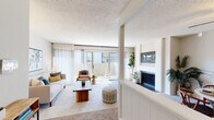 This single-floor model unit at Club at IC in Overland Park, Kansas, presents a well-designed layout with comfortable living spaces throughout. The living room serves as a central gathering area, featuring a wood-burning fireplace with a sleek dark surround, a wall-mounted television niche above, and floor-to-ceiling sliding glass doors that flood the space with natural light while providing direct access to a private outdoor patio. Soft carpeting and a textured ceiling complete the room's comfortable character.

Adjacent to the living room, the dining area accommodates a full-sized table and benefits from a ceiling fan overhead. It connects seamlessly to the kitchen, which features white cabinetry with brushed nickel hardware, gray countertops, a tile backsplash, and black appliances including a gas range.

The bedroom offers generous proportions with plush carpeting, a large window for natural light, and a dedicated closet with hanging storage. The full bathroom is clean and functional, equipped with a tub-shower combination and white surround. Throughout the unit, a neutral color palette of whites and soft grays creates a cohesive, inviting atmosphere well-suited to everyday living.