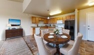 This 710 square foot apartment in Dickinson, North Dakota offers a well-designed living space on a single floor. The layout comprises one bedroom, one bathroom, a closet, and an open-concept kitchen and living room area. The primary bedroom, measuring 140 square feet, provides ample space and features carpeted flooring and a window air conditioning unit for comfort.

The bathroom is equipped with a modern white tub-shower combination and includes convenient storage options. The apartment boasts a generously sized closet with wire shelving, offering abundant storage space. The kitchen is a standout feature, with honey-colored wooden cabinetry, a central island, and white appliances, all set against attractive brown tiled flooring.

Large windows in the living area and bedroom allow for plenty of natural light, while a sliding glass door leads to a private balcony, offering outdoor views and fresh air. The apartment is finished with neutral-toned walls and carpeting throughout the living spaces, creating a bright and inviting ambiance. Climate control is provided by baseboard heating and window air conditioning units, ensuring year-round comfort in Dickinson's varying climate.