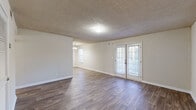 Located at 3954 Memorial College Ave in Clarkston, GA, this single-floor home offers a thoughtfully laid-out interior with a neutral color palette and a variety of flooring options throughout. The open living and dining areas are finished with durable wood-style flooring and textured ceilings, creating a clean and cohesive aesthetic. A standout feature of the living area is a set of French doors that lead to an outdoor space, filling the room with natural light and providing convenient exterior access. A chandelier accent in the dining area adds a subtle decorative touch.

The kitchen is efficiently designed with white cabinetry, white appliances including a range, dishwasher, and refrigerator, along with light wood-style flooring that ties the space together. The bedrooms are carpeted for comfort, each featuring windows that allow natural light and a calm, neutral atmosphere. Closet access is included in the bedroom areas for practical storage.

The bathroom is well-appointed with a tub/shower combination, white vanity with countertop, and wood-style flooring. An in-unit laundry area with a dedicated electrical hookup and shelving provides added convenience. Overall, the home presents a clean, move-in-ready layout suited for comfortable everyday living.