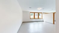 Located at 6 Delprete Ave, Unit 107 in Rockland, MA, this one-bedroom, one-bathroom residence offers a thoughtfully arranged single-floor layout with a clean, modern aesthetic throughout. The kitchen is a standout feature, equipped with abundant white shaker-style cabinetry, a soft green subway tile backsplash, white appliances including a range and refrigerator, and ample counter space — all complemented by neutral flooring that keeps the space feeling bright and cohesive. Rich wood-trimmed doors add a warm contrast to the crisp white walls found throughout the unit. The bedroom is generously sized, featuring plush carpeting, natural light from wood-framed windows with views of the surrounding neighborhood, and a dedicated closet for storage. The full bathroom is well-appointed with a walk-in shower unit equipped with grab bars and shelving, a white vanity with storage, and light-toned flooring, offering both functionality and comfort. The open living area provides a flexible, spacious feel with clean lines and neutral finishes. The overall ambiance is bright, clean, and move-in ready, making this unit a practical and comfortable home in Rockland, MA.