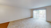 Located at Bercado Place in Mishawaka, Indiana, this single-floor unit offers a thoughtfully designed layout with a comfortable mix of functional spaces. The living area is generously sized, featuring soft wall-to-wall carpeting and vertical blinds framing a sliding glass door that opens to an outdoor area, allowing natural light to fill the room. Adjacent to the living area is a dedicated dining space, highlighted by warm hardwood-style laminate flooring and an elegant chandelier that adds a refined touch overhead. The kitchen is well-equipped and efficiently arranged in a U-shaped configuration, showcasing warm wood cabinetry, light stone-patterned countertops, a double-basin sink, and recessed lighting. Black appliances, including a full-size refrigerator and gas range, complete the functional cooking space. The bedroom continues the warm, carpeted aesthetic and includes a ceiling fan with a light fixture and a window that brings in natural light with views of the surrounding greenery. The full bathroom features tile flooring, a tub-shower combination with a white surround, a wood-framed vanity mirror, and a single-basin sink, offering a clean and practical design. Overall, this unit presents a cohesive, move-in-ready interior with consistent finishes throughout.