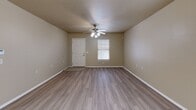 Located at 1919 NW 142nd St in Oklahoma City, Oklahoma, this single-story, 2-bedroom, 2-bathroom home offers a practical and well-organized layout. The combined kitchen and living area forms the heart of the home, with the living room featuring durable wood-look flooring, neutral warm-toned walls, ceiling fans with integrated lighting, and windows fitted with blinds that allow for natural light. An elegant chandelier adds a decorative accent to the dining area transition. The kitchen is outfitted with rich, dark wood cabinetry, granite-style countertops, tile flooring, and black appliances including a range and dishwasher, providing ample storage and prep space. Both bedrooms continue the wood-look flooring and warm neutral palette, each equipped with ceiling fans and windows for ventilation and light. The spacious primary bedroom offers a generous footprint with closet access. Both bathrooms mirror each other in style, featuring warm wood vanity cabinetry, granite-topped sinks, tile flooring, and accessible tub/shower combinations complete with safety grab bars — thoughtful touches that enhance usability. A hallway and dedicated closet round out the floor plan, keeping the layout organized and efficient throughout.