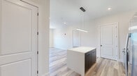 Located on the penthouse level at 196 Dayton Ave in Passaic, NJ, this thoughtfully designed 2-bedroom, 2-bathroom residence delivers a clean, modern aesthetic across a well-utilized single floor. Light-toned wood-style flooring runs throughout, creating a cohesive and airy feel in every room.

The kitchen is a standout feature, boasting bold navy cabinetry that extends floor to ceiling, a matching center island with a crisp white countertop, a dark tile backsplash, and a full suite of stainless steel appliances including a gas range, built-in microwave, and a French door refrigerator. Pendant lighting adds a refined touch above the island.

Both bedrooms are generously proportioned, featuring neutral walls, recessed lighting, and windows that invite natural light and outdoor views. The spacious primary bedroom includes a dedicated closet. Each room is equipped with a wall-mounted HVAC unit for individual climate control.

The two bathrooms are finished with contemporary style. One features a floating navy vanity with a white basin, black fixtures, and a framed mirror. The second bathroom offers a full tub-shower combination enclosed by sliding glass doors, complemented by large-format tile surround, a matching navy vanity, and black-framed mirror — both spaces conveying a polished, hotel-like quality.