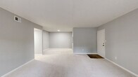 Located at 500 Hambrick Rd in Stone Mountain, GA, this single-story, 3-bedroom, 3-bathroom home offers a well-organized layout with a living room, dining room, kitchen, laundry, and six closets. The interior is finished in a consistent neutral gray palette with crisp white trim and baseboards throughout, creating a clean and cohesive aesthetic.

The spacious living and dining areas feature plush wall-to-wall carpeting and an open feel, with natural light streaming in through multiple windows fitted with blinds. A secondary entrance with a dark hardwood threshold connects the living space to the outside.

The kitchen stands out with white shaker-style cabinetry, granite-look countertops, a subway tile backsplash, and stainless steel appliances including a range and refrigerator. Wood-look luxury vinyl plank flooring anchors the kitchen's modern, functional design.

Each bedroom is carpeted and bright, with windows overlooking the surrounding greenery. Several bedrooms include louvered bi-fold closet doors, providing ample storage. The primary bedroom offers a generous footprint with multiple windows.

The three bathrooms are finished with white vanities, granite-look countertops, dark wood-look flooring, and tiled shower/tub combinations with chrome fixtures, delivering a clean and updated look throughout.