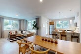 Located at 3101 184th St SW in Lynnwood, WA, this well-appointed 2-bedroom, 3-bathroom residence offers a thoughtfully designed single-floor layout. The open-concept living, dining, and kitchen area forms the heart of the home, bathed in natural light from large windows that frame views of the surrounding greenery. Light hardwood-style flooring flows throughout, complementing the clean, contemporary aesthetic.

The kitchen is a standout feature, showcasing a two-tone design with warm wood lower cabinetry and crisp white upper cabinets, white quartz countertops, stainless steel appliances, and a practical peninsula with bar seating. The living area is generously proportioned, with expansive windows lending an airy, open feel.

The primary bedroom offers a comfortable retreat with direct access to an en-suite bathroom. A second bedroom features a large window with outdoor views. All three bathrooms are finished with white vanities, hexagonal tile flooring, and clean, modern fixtures — some including walk-in showers.

A dedicated hallway houses in-unit laundry, adding everyday convenience. Three closets provide ample storage throughout. The residence also includes a private patio, extending the living space outdoors. The overall design is modern and cohesive, with a neutral palette and quality finishes throughout.