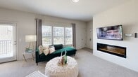 This single-floor residence offers four bedrooms and two bathrooms within a thoughtfully designed layout. The living room serves as the heart of the home, featuring a built-in electric fireplace, large windows with slatted blinds that invite abundant natural light, and views of the surrounding neighborhood. Plush carpeting runs throughout the living and bedroom areas, complemented by light wood-look tile flooring in the kitchen.

The kitchen is a functional standout, equipped with dark espresso cabinetry, a white subway tile backsplash, stainless steel appliances including a French door refrigerator, and a peninsula with striking marble-look countertops — mirrored in both bathrooms as well. A skylight overhead adds additional brightness to the space.

Each of the four bedrooms offers a ceiling fan, carpeted floors, and closet space, with the primary bedroom providing a notably spacious footprint. The secondary bedrooms are well-proportioned and versatile.

Both bathrooms feature large vanity mirrors, dark cabinetry with contemporary hardware, and marble-look countertops. The neutral, warm color palette used throughout the home creates a cohesive and inviting ambiance, making this a practical and comfortable residence suited for a variety of living arrangements.