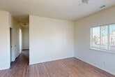 Located at 736 Olivera St in Guadalupe, California, this single-story home offers four bedrooms and three bathrooms within a thoughtfully arranged floor plan. The interior is finished with warm wood-look vinyl flooring throughout the main living areas and bedrooms, providing a cohesive and easy-to-maintain aesthetic.

The kitchen is well-appointed with warm oak cabinetry offering ample upper and lower storage, granite-look countertops, a gas range, stainless steel refrigerator, and tile flooring. A window above the sink allows for natural light to brighten the space. The adjacent living room is open and bright, connected to the rest of the home via a central hallway.

Each of the four bedrooms features clean white walls, wood-look flooring, and windows that invite natural light and provide views of the surrounding neighborhood. At least one bedroom includes a built-in closet with a sliding panel door, while the primary bedroom offers a more generous footprint. The bathrooms are finished with tile flooring and include features such as oak vanities with granite-look countertops, large mirrors, and a tiled shower-tub combination. The overall ambiance of the home is clean, neutral, and move-in ready.