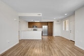 Unit 104 at 16340 Lasselle St is a well-appointed single-floor residence designed with a clean, modern aesthetic and a practical open-concept layout. The entry welcomes you into a bright, airy living area finished with light wood-look flooring that extends throughout the main living spaces, lending warmth and continuity to the interior.

The kitchen is a functional centerpiece of the home, featuring rich wood cabinetry, light-toned countertops, and a full suite of stainless steel appliances, including a gas range, over-the-range microwave, and a side-by-side refrigerator. The layout offers ample counter and storage space, making it well-suited for everyday cooking. Conveniently tucked nearby is an in-unit laundry area, adding to the home's practicality.

The living area is generously sized and bathed in natural light from a bank of windows fitted with blinds, creating a bright and welcoming atmosphere. The bedroom is carpeted for comfort and includes a window that allows natural light to filter in. The bathroom is neatly finished with wood-look flooring, a single-sink vanity with a wide mirror, and a tub-shower combination with clean tile surround. Overall, the unit presents a fresh, move-in-ready environment with cohesive finishes throughout.