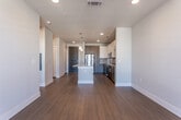Located at 915 Glenwood Ave SE in Atlanta's vibrant Glenwood Park neighborhood, this modern single-floor residence offers a well-designed, open-concept layout with contemporary finishes throughout. The kitchen serves as the centerpiece of the living space, showcasing a large granite-topped island with pendant lighting overhead, crisp white upper cabinetry, rich dark wood lower cabinetry, a subway tile backsplash, and a full suite of stainless steel appliances including a refrigerator, range, microwave, and dishwasher. Warm hardwood-style flooring flows seamlessly from the kitchen into the living area, which is bathed in natural light and features a ceiling fan and French doors leading to a private balcony. The bedroom offers plush carpet flooring, a ceiling fan, and a window with exterior views, providing a comfortable and quiet retreat. The bathroom is finished with clean, modern horizontal white tile surrounding a full soaking tub. Recessed lighting throughout the unit enhances the bright, airy ambiance. The overall design balances functionality with contemporary style, making this a polished and move-in-ready space in one of Atlanta's sought-after neighborhoods.