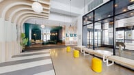 Located at 1240-1250 Cummings Ave in Ottawa, this single-floor amenity space offers an expansive and thoughtfully curated environment that blends bold design with functional comfort. The grand entrance lobby sets the tone immediately, featuring a dramatic sculptural archway of layered white ribs, polished concrete flooring, and a welcoming reception area framed by lush greenery and globe pendant lighting. A striking feature wall displaying large typographic lettering in teal, gold, and white serves as a bold visual anchor near the entryway corridor.

The space flows into multiple distinct zones, including a lounge area bathed in natural light through floor-to-ceiling black-framed windows, furnished with plush teal curved sofas, upholstered armchairs, and elegant pendant lighting with exposed Edison bulbs. A games and social area features a full-size pool table beneath warm gold dome pendants, complemented by a billiards cue rack and casual dining seating with a teal accent wall.

A bar and lounge zone offers high-top seating with quilted chairs, additional dining tables, and sweeping outdoor views. The elevator lobby is distinguished by a sleek dark surround and carpeted flooring, providing a refined transition point. Throughout, the design palette of teal, gold, warm neutrals, and polished concrete creates a cohesive, vibrant, and upscale communal atmosphere.