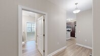 This single-story residence offers a thoughtfully designed layout with 2 bedrooms, 3 bathrooms, and two closets. The open-concept kitchen and living area serves as the heart of the home, featuring light wood-style flooring, neutral warm-gray walls, and abundant natural light streaming through large windows and a glass door that leads to the outdoors. The kitchen stands out with a central island topped with granite countertops, an undermount sink, stylish pendant lighting, rich dark-brown cabinetry, and stainless steel appliances. The living area extends naturally from the kitchen, creating a seamless and functional shared space. The primary bedroom is generously sized and includes a ceiling fan, a walk-in closet with wire shelving, and an en-suite bathroom. The second bedroom also features a ceiling fan, plush carpet flooring, and a bright window. Both bedrooms are finished in the same calming neutral palette found throughout the home. The bathrooms are consistently appointed with granite-topped dark vanities, framed mirrors, and light wood-style tile flooring. A walk-in closet with wrap-around wire shelving provides ample storage. The overall ambiance is clean, modern, and move-in ready.