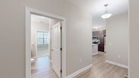 This single-story residence offers a thoughtfully designed layout with 2 bedrooms, 3 bathrooms, and two closets. The open-concept kitchen and living area serves as the heart of the home, featuring light wood-style flooring, neutral warm-gray walls, and abundant natural light streaming through large windows and a glass door that leads to the outdoors. The kitchen stands out with a central island topped with granite countertops, an undermount sink, stylish pendant lighting, rich dark-brown cabinetry, and stainless steel appliances. The living area extends naturally from the kitchen, creating a seamless and functional shared space. The primary bedroom is generously sized and includes a ceiling fan, a walk-in closet with wire shelving, and an en-suite bathroom. The second bedroom also features a ceiling fan, plush carpet flooring, and a bright window. Both bedrooms are finished in the same calming neutral palette found throughout the home. The bathrooms are consistently appointed with granite-topped dark vanities, framed mirrors, and light wood-style tile flooring. A walk-in closet with wrap-around wire shelving provides ample storage. The overall ambiance is clean, modern, and move-in ready.