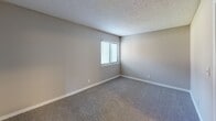 Located at 9007 Ten Mile Rd in Knoxville, Tennessee, this one-bedroom, one-bathroom residence offers a well-organized single-floor layout designed for comfortable everyday living. The combined dining and kitchen area serves as a functional hub of the home, featuring white cabinetry extending to the ceiling for generous storage, dark granite-style countertops, light wood-look flooring, and a full suite of appliances including a refrigerator, electric range, dishwasher, and an over-range ventilation hood. A hallway connects the main living areas to the private quarters, with three closets distributed throughout the unit providing ample storage solutions. The spacious bedroom is finished with plush carpeting, neutral gray walls, a textured ceiling, and a window fitted with blinds that allow for natural light and privacy control. The bathroom features a granite-style vanity countertop with an undermount sink and white cabinetry, maintaining a consistent design language with the kitchen. A utility room adds practical functionality to the layout. The living room offers additional carpet-covered space ideal for relaxing or entertaining. A private balcony extends the living space outdoors, providing a pleasant retreat. Throughout the unit, a cohesive neutral palette and clean finishes create a calm, move-in-ready atmosphere.