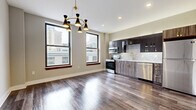 Located at 13 S Jefferson St in the heart of downtown Dayton, Ohio, this thoughtfully designed one-bedroom, one-bathroom unit offers a compelling blend of modern finishes and urban convenience. Rich hardwood-style flooring runs throughout the entire space, anchoring a cohesive and contemporary aesthetic.

The open-concept kitchen and living area serves as the centerpiece of the unit. The kitchen is outfitted with two-tone cabinetry — dark upper cabinets contrasted by wood-grain lower cabinets — accented with gold hardware. A textured diamond-pattern tile backsplash, white quartz countertops, a gold-finish faucet, and stainless steel appliances including a range, microwave, and dishwasher complete the well-appointed kitchen. A statement mid-century modern chandelier with gold and black tones adds character to the living area, which is bathed in natural light from large windows offering dynamic downtown Dayton city views.

The bedroom is a calm, neutral retreat with a ceiling fan and access to a walk-in closet with built-in shelving and a dedicated laundry area. The bathroom features marble-look tile flooring, a walk-in shower with large-format tile walls, a wood-grain vanity, and a quartz countertop — delivering a clean, spa-like atmosphere. This unit is a refined urban residence in the core of Dayton's downtown corridor.