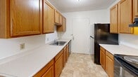 Located at 45 Village Brook Ln in Natick, MA, this single-floor, one-bedroom, one-bathroom residence offers a practical and comfortable layout. The kitchen is well-appointed with warm oak cabinetry, white countertops, tile flooring, and black appliances including a range and refrigerator. A double sink and generous counter space make it functional for everyday cooking. The kitchen opens toward the living area, which features soft carpeting, a ceiling fan with light fixture, and two windows that bring in natural light and neighborhood views, creating a bright and airy atmosphere. The spacious primary bedroom provides a comfortable retreat with plush carpeting and a large double sliding-door closet, offering abundant storage. The full bathroom is finished with earthy stone-look tile flooring, a wood-toned vanity with a marble-style countertop, and a tiled shower-tub combination. Outside, a private yard enclosed by a tan vinyl privacy fence with lattice detailing provides a peaceful outdoor space with mature trees adding a natural backdrop. The clean, neutral palette throughout the interior offers a versatile canvas, while the efficient single-level layout ensures ease of living. Situated in Natick, residents enjoy convenient access to local amenities, shopping, and commuter routes.