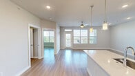 Located along RM-620 in Austin, TX, this well-appointed one-bedroom, one-bathroom residence offers a thoughtfully designed open-concept layout with modern finishes throughout. Light wood-tone flooring flows seamlessly across the entire space, creating a cohesive and inviting atmosphere.

The combined kitchen and living area serves as the heart of the home. The kitchen is outfitted with rich dark wood cabinetry extending to the ceiling, a white quartz waterfall-edge island with an undermount sink, a tile backsplash, and a full suite of stainless steel appliances including a gas range, built-in microwave, and refrigerator. Elegant pendant lighting above the island adds a refined touch.

The living area benefits from large windows and a glass-panel door that flood the space with natural light and provide elevated views of the surrounding Austin Hill Country landscape.

The bedroom is a comfortable retreat featuring a ceiling fan, generous windows with scenic outdoor views, and direct access to the bathroom and closet. The bathroom is well-appointed with dark wood cabinetry, a white quartz double vanity, a large wall mirror, and a glass-enclosed walk-in shower with marble-style tile surround. A dedicated closet completes the private quarters, offering practical storage solutions.