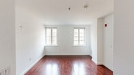 Located in Philadelphia's historic Old City neighborhood, this penthouse at 22 N Front St offers a thoughtfully designed multi-floor layout with 4 bedrooms, 2 bathrooms, and a private rooftop deck. The main floor serves as the heart of the home, featuring a generously sized open-plan living room bathed in natural light from large multi-pane windows, with richly stained hardwood floors that extend throughout. The well-appointed kitchen is a standout, showcasing warm cherry wood cabinetry, dark granite countertops, stainless steel appliances including a gas range, built-in microwave, and French door refrigerator, along with a deep double-basin sink set into a center island. The four bedrooms offer comfortable, well-lit spaces with plush carpeting and ample natural light from windows overlooking the surrounding cityscape. Both bathrooms are finished with light tile flooring, clean white subway tile surrounds, and dark granite vanity tops with undermount sinks and chrome fixtures. A utility room and multiple staircases connect the floors efficiently. The crown jewel of the property is the expansive private rooftop deck, delivering panoramic views of the Philadelphia skyline, including iconic steeples and the dynamic Old City streetscape.