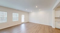 Located at 407 Lettie Ln in Rolesville, NC, this two-story home offers a well-designed layout spread across two floors. The main level welcomes you through a dedicated entrance that opens to a combined dining and living area, filled with natural light from large windows and finished with light-toned hardwood-style flooring. Recessed lighting enhances the bright, clean aesthetic throughout. The kitchen is a standout feature, showcasing white shaker cabinetry, quartz countertops, a classic tile backsplash, and a full suite of stainless steel appliances, including a French door refrigerator, electric range, built-in microwave, and dishwasher. A patio door leads to the backyard, which is enclosed by a white vinyl privacy fence and black iron fencing, with a concrete patio and a serene wooded backdrop. The attached garage offers additional storage and utility space. Upstairs, three bedrooms provide comfortable retreats, including a generously sized primary suite with its own walk-in closet fitted with wire shelving. Bathrooms feature tile flooring, white vanities with gold-toned hardware, and tub-shower combinations. A dedicated laundry room with a full-size washer and dryer and wire shelving adds everyday convenience. With seven closets total, storage is plentiful throughout this clean, move-in-ready home.