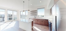 Located at 19888 40th Avenue West in Lynnwood, WA, this thoughtfully designed one-bedroom, one-bathroom unit offers a modern living experience with clean lines and contemporary finishes throughout. The open-concept layout centers around a striking kitchen, which features warm wood-toned cabinetry with matte black hardware, a white quartz waterfall island, subway tile backsplash, stainless steel appliances including a refrigerator, range, and microwave, and floating shelves for additional storage. Pendant globe lights hang above the island, adding a stylish focal point. Large windows flood the space with abundant natural light and provide views of the surrounding Lynnwood landscape, enhancing the airy, bright ambiance. Light wood-style flooring flows consistently throughout the unit, complementing the neutral white walls. The bedroom is a well-proportioned retreat bathed in natural light from a dedicated window, and includes a walk-in closet with wire shelving. The full bathroom offers a soaking tub with shower combo and oil-rubbed bronze fixtures. A dedicated laundry area adds everyday convenience, while the private balcony extends the living space outdoors. The bold yellow entry door adds a welcoming pop of character to this polished, move-in-ready home.