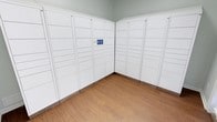 The Packaging Center is a purpose-built space designed to streamline the secure storage and retrieval of parcels. The room is lined on two walls with a comprehensive array of smart parcel lockers finished in clean white, offering compartments in multiple sizes to accommodate packages of varying dimensions. The lockers are equipped with a digital interface panel, enabling users to easily access their deliveries through a modern, tech-integrated system. The space features warm wood-look flooring that provides a welcoming contrast to the crisp white locker units, while the light gray walls and neutral ceiling contribute to a bright, clean atmosphere. The layout is thoughtfully organized, with the locker banks arranged in an L-shaped configuration that maximizes storage capacity while keeping the space open and easy to navigate. The overall design prioritizes functionality and ease of use, making it a practical and efficient hub for package management.