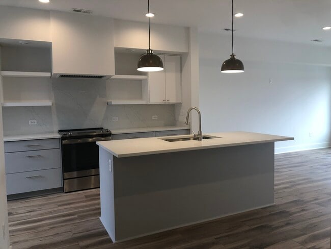 Kitchen island with quartz countertops and solid natural stone backsplash - 510 Court St