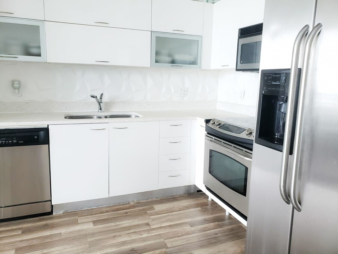 Remodeled kitchen. Comes with amenities such as fridge, stove, microwave and dishwasher. Other amenities at the apartment are washer and dryer. - 133 NE 2nd Ave